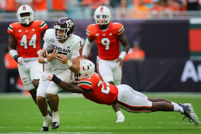 Sep 9, 2023; Miami Gardens, Florida, USA; Texas A&M Aggies quarterback Conner Weigman (15) runs with the football against Miami Hurricanes linebacker K.J. Cloyd (23) during the second quarter at Hard Rock Stadium. Mandatory Credit: Sam Navarro-USA TODAY Sports